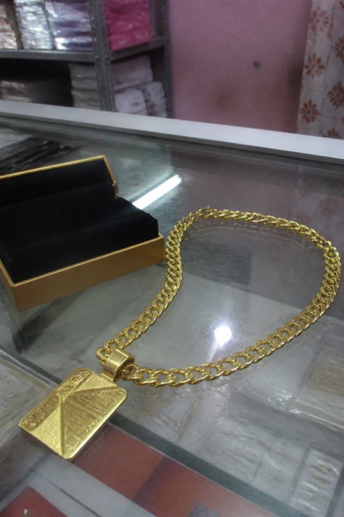 Original photo: gold necklace lying on a glass shop counter